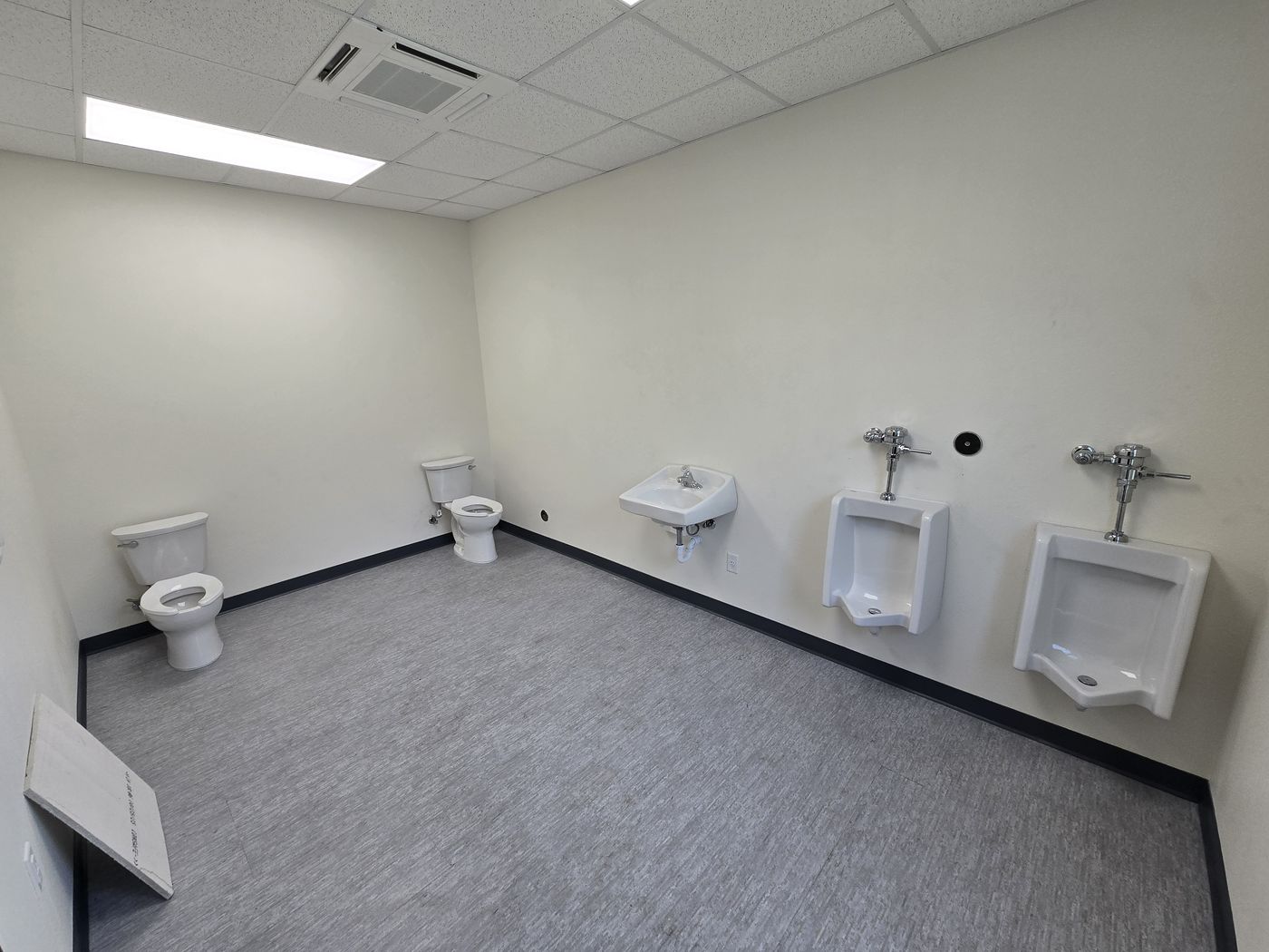 Finished commercial restroom with flush valves and urinals