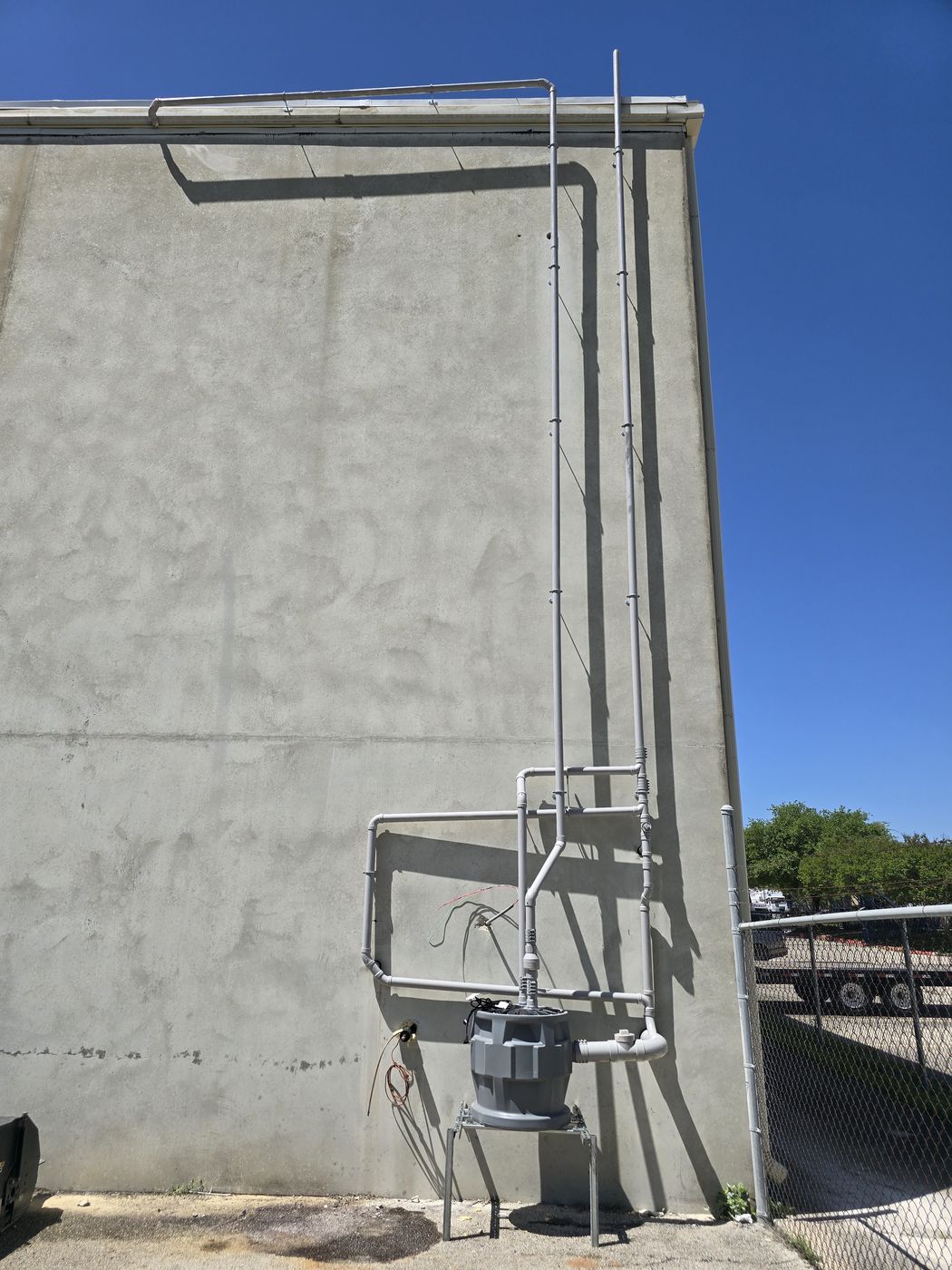 Sewage ejector basin and vent risers on a tilt-wall warehouse at Alamo Tees