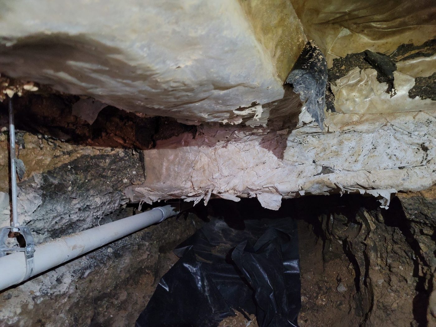 A branch tee under a slab with a riser to a fixture, hung on threaded rod