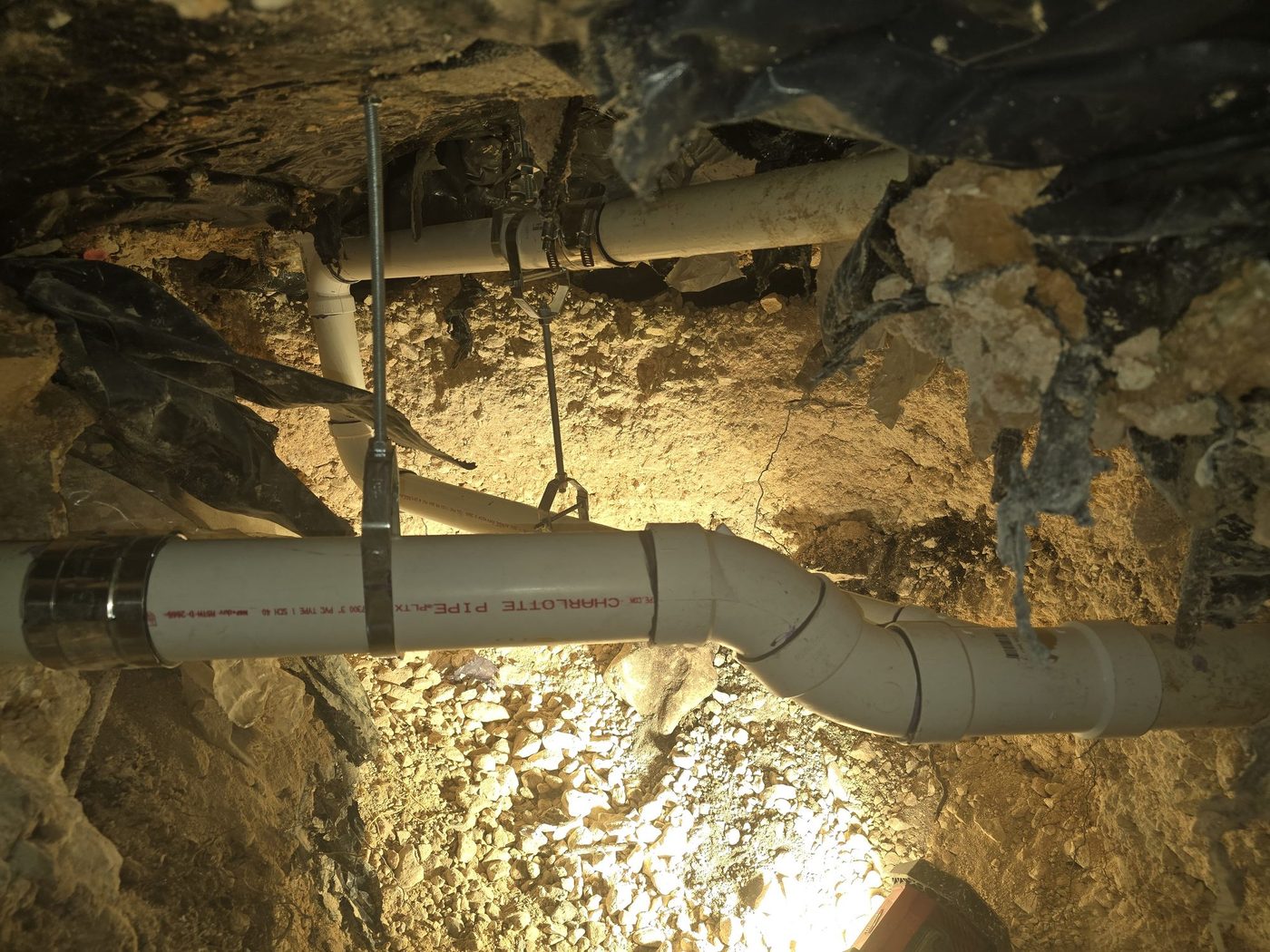 A wye fitting on a drain line in a tunnel, joined with shielded couplings