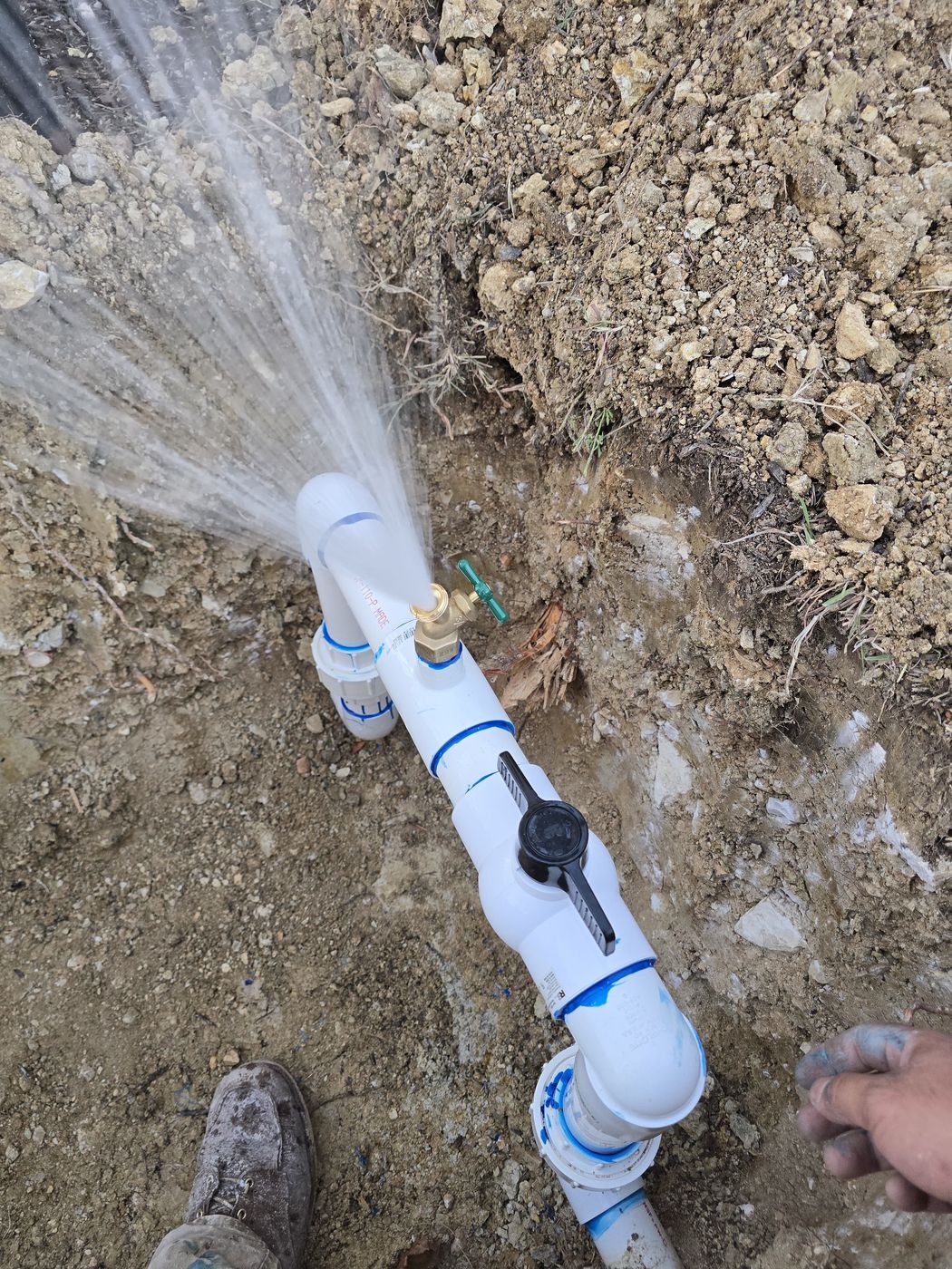 A new water service being flushed clear by hand before it is tied in